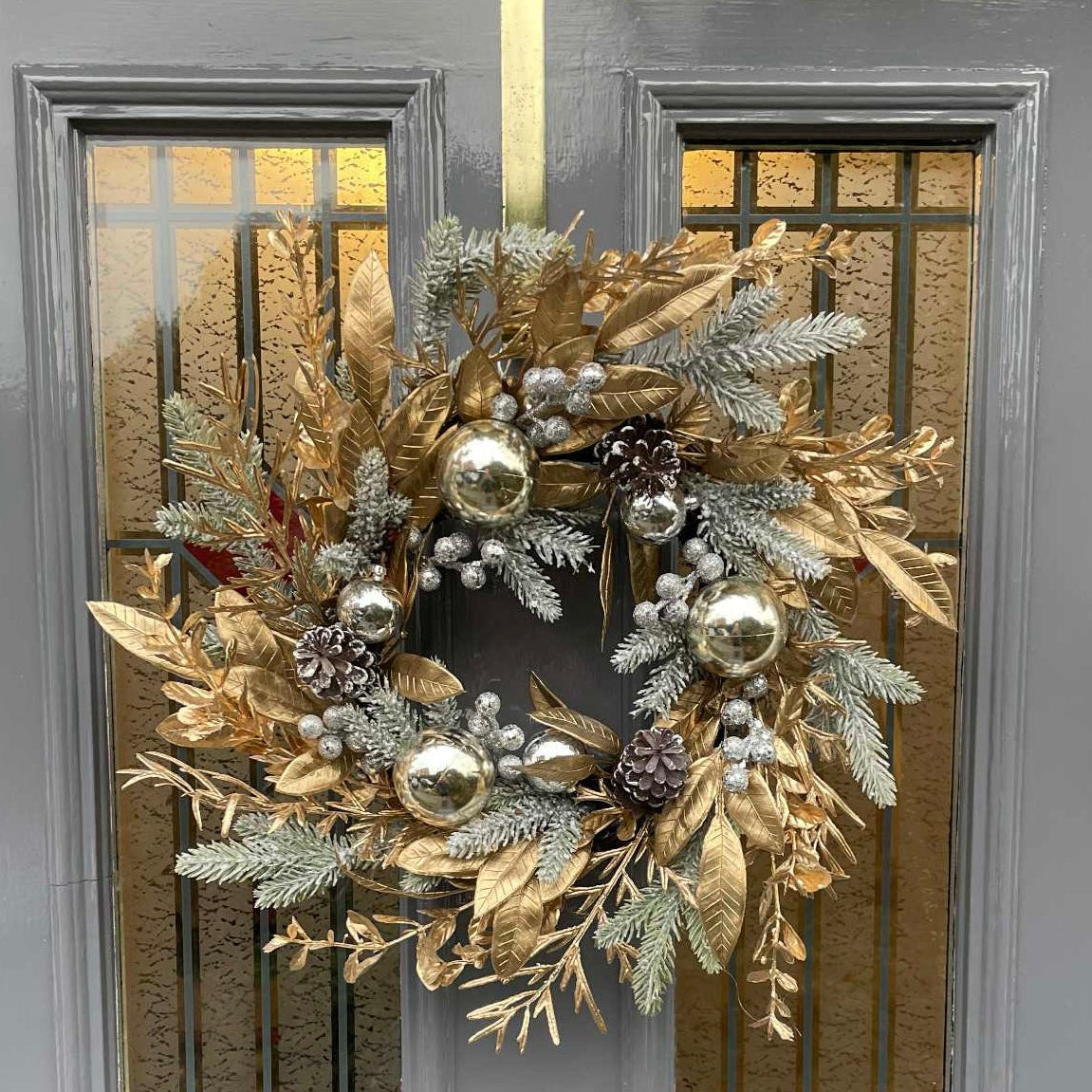 Decorative wreath with gold and silver elements on a door