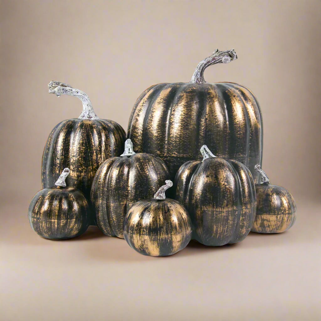 Set of metallic gold and brown faux pumpkins on a white background