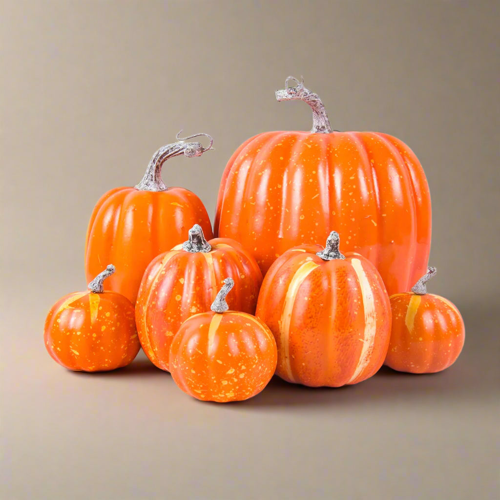 Group of orange faux pumpkins on a white background