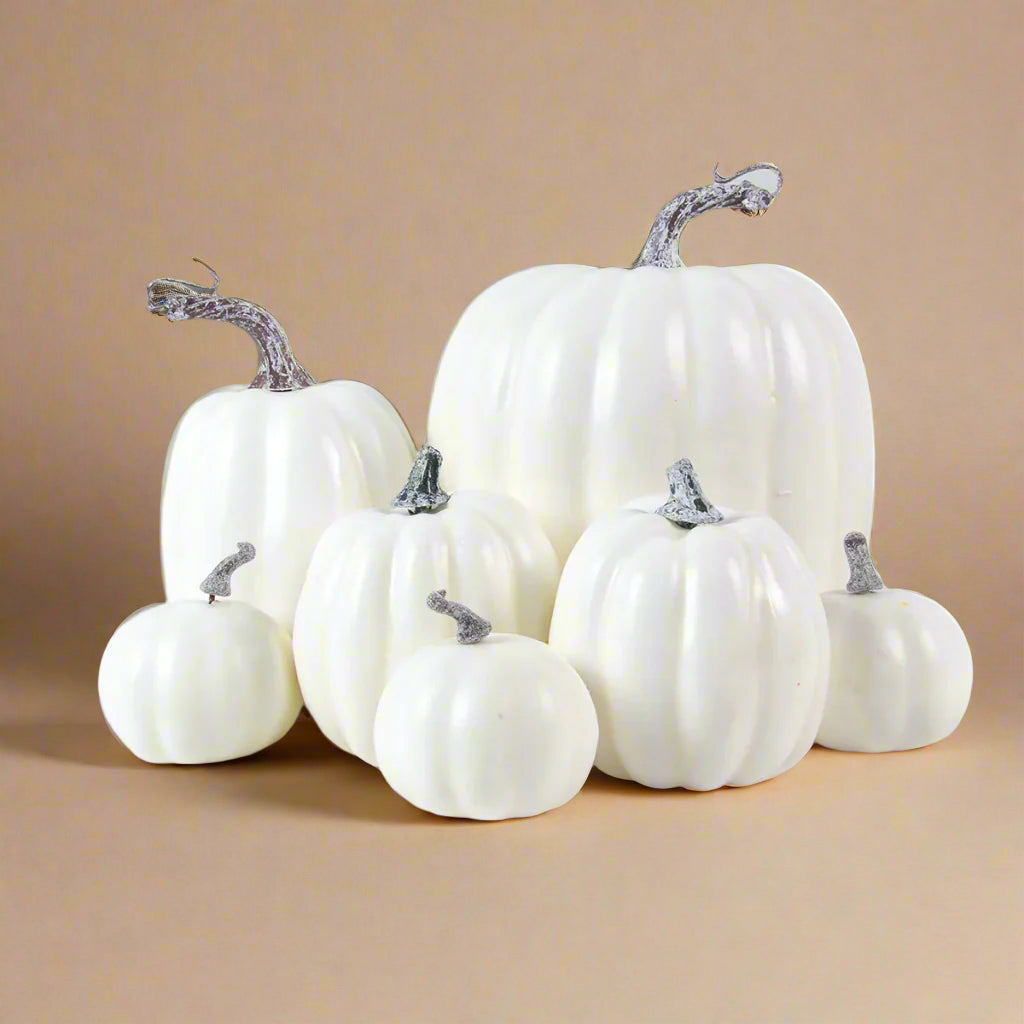 White faux pumpkins with grey stems on a white background