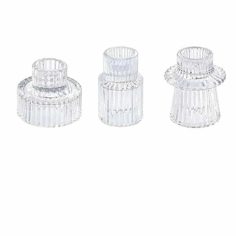 Three clear glass candle holders on a white background