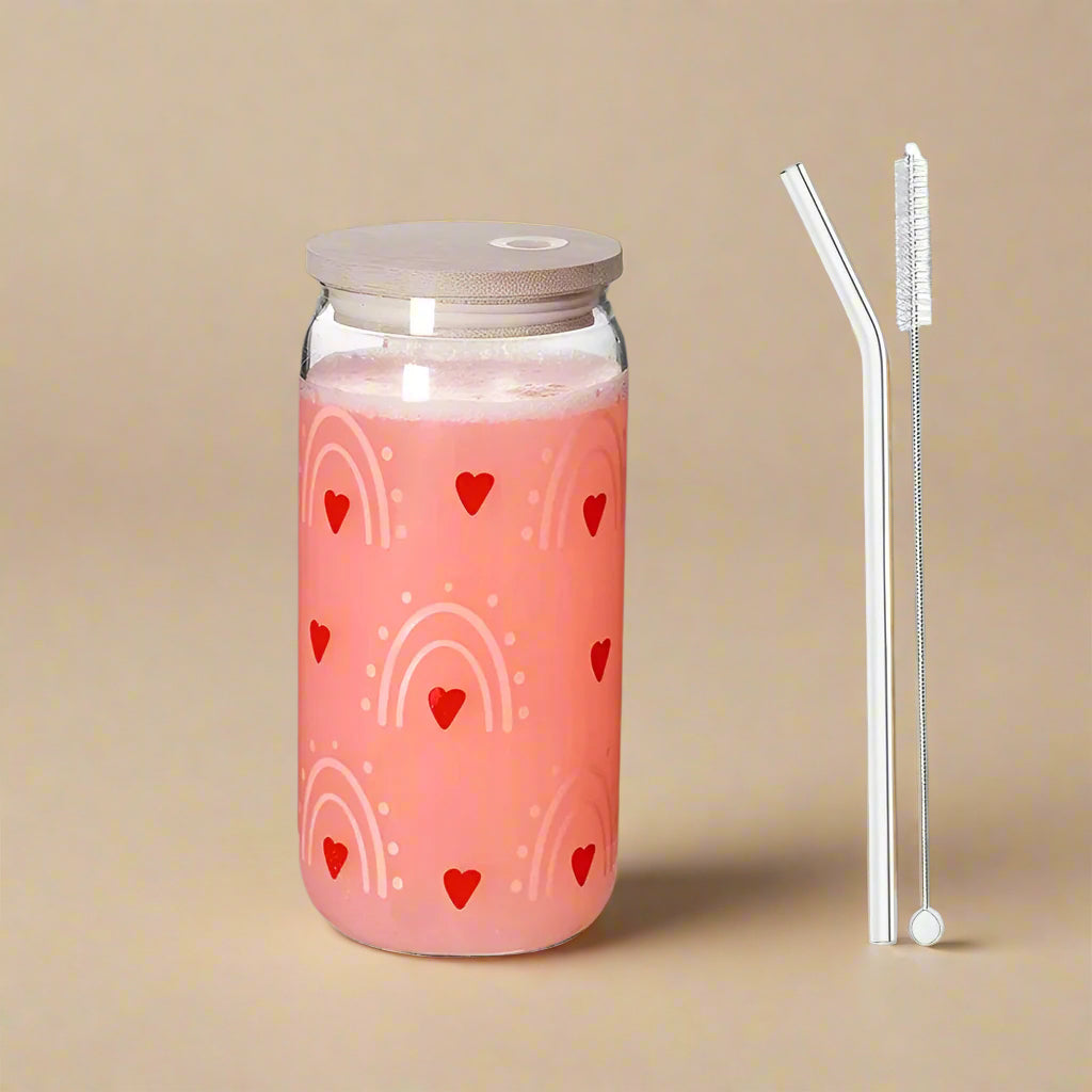 Glass tumblers with heart & rainbow printed design, one pink and one white, with wooden lid and straw.