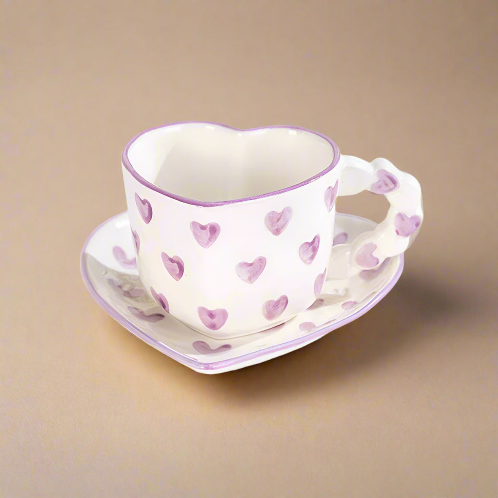 Ceramic heart-shaped mug with purple, hand-painted heart patterns.