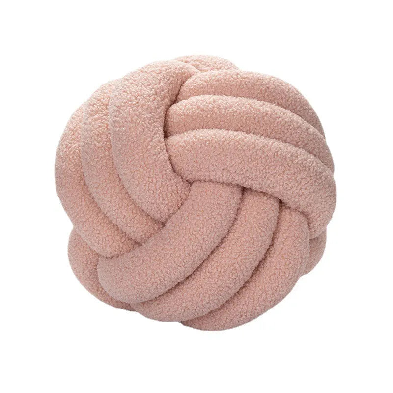 Pink knotted pillow on a white background
