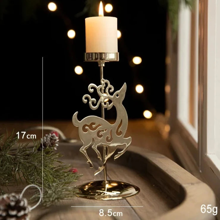 A gold metal candle holder with a festive reindeer engraving