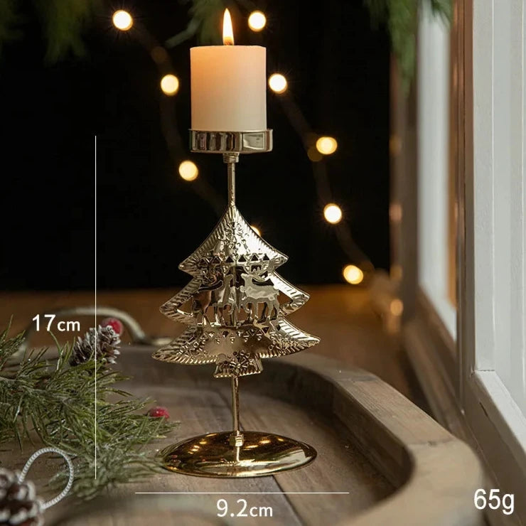 A gold metal candle holder with a festive Christmas tree engraving