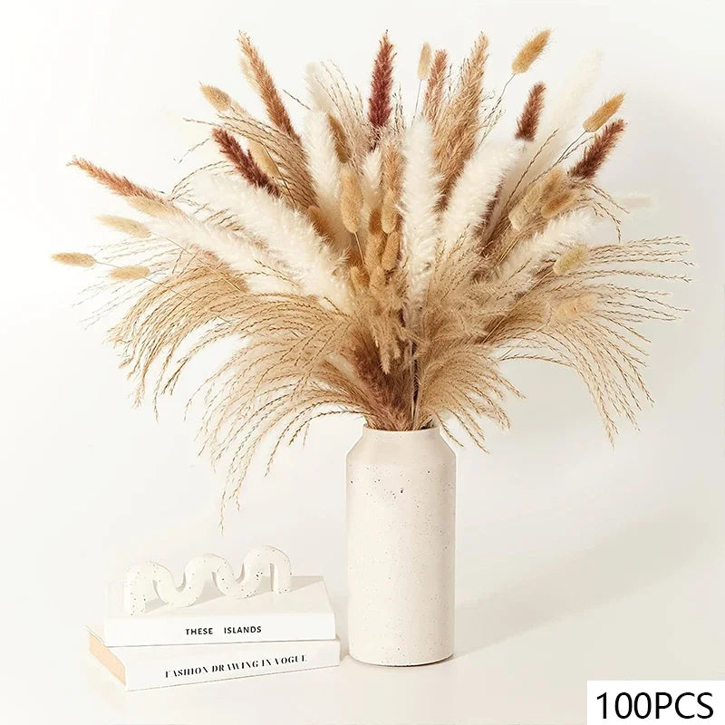 A white ceramic vase containing a dried pampas arrangement