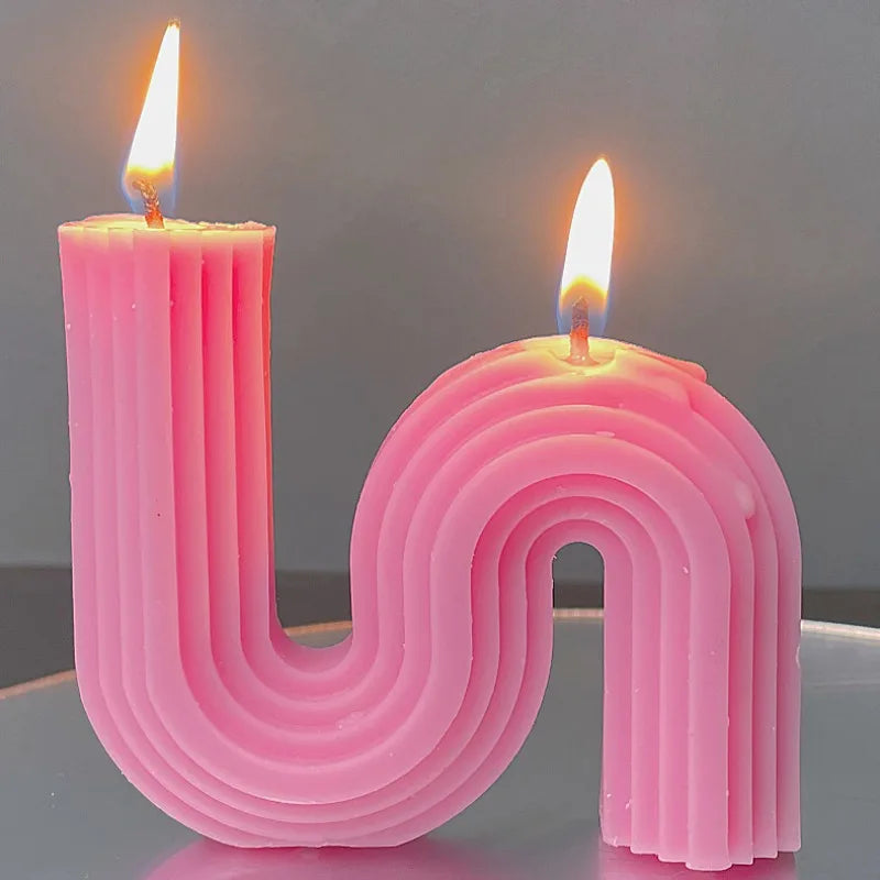 A decorative S-shaped candle made from soy wax in the colour dark pink
