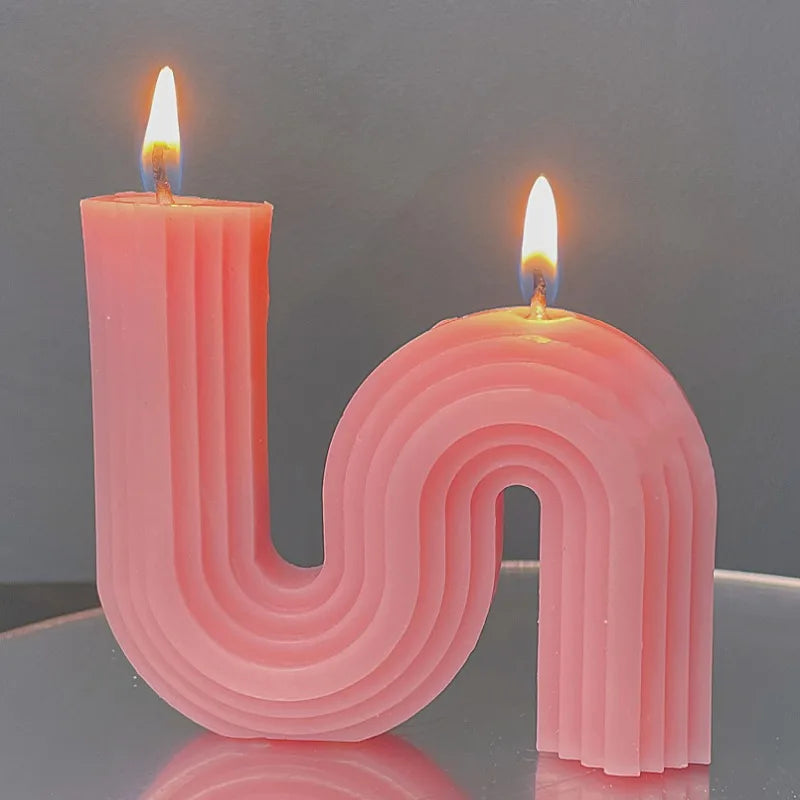 A decorative S-shaped candle made from soy wax in the colour flesh pink