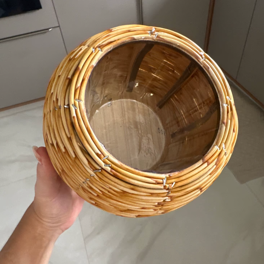 Hand holding a woven basket in a kitchen setting
