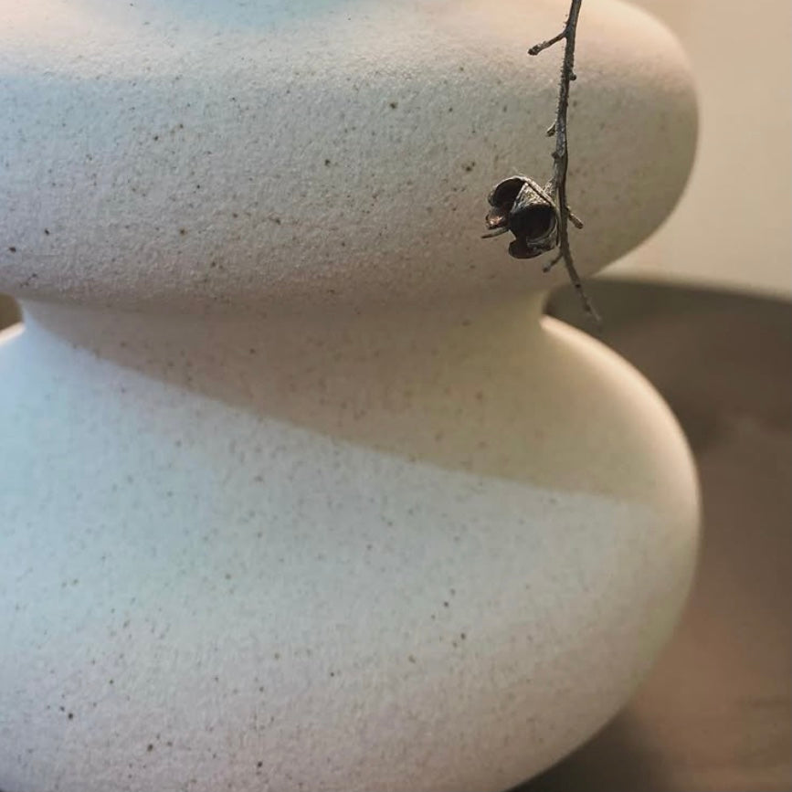 Close-up of white wavy ceramic vase showing the texture of the ceramic detailing