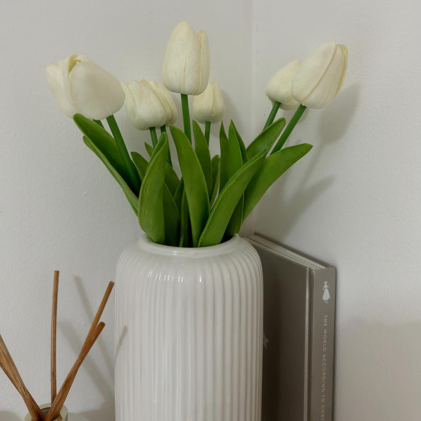 White ceramic flower vase with minimalist design, styled with tulips and a reed diffuser.