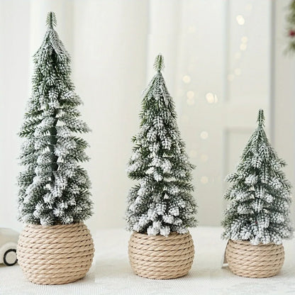 Three artificial snowy Christmas trees in different sizes with a rustic linen, burlap wrapped base, displayed on a table with a festive background.