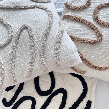 Textured throw pillows with abstract patterns on a light background