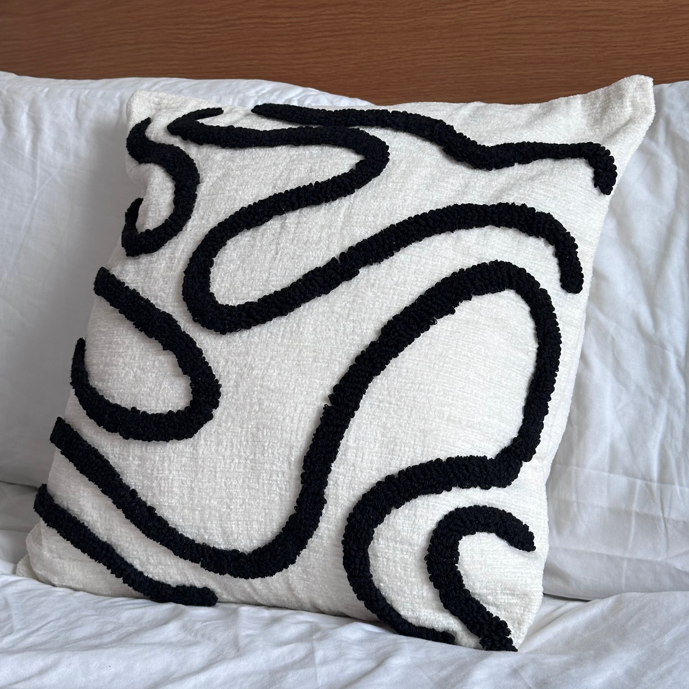 Decorative pillow with black abstract patterns on a white background