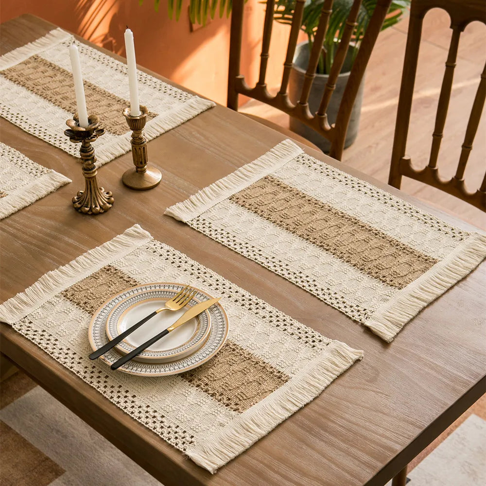 Table setting with boho farmhouse placemats, plates and cutlery on a wooden table.