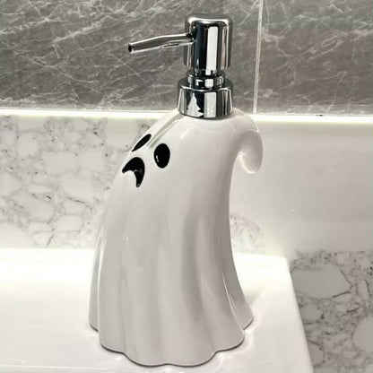 Ghost-shaped soap dispenser with a metallic pump on a marble countertop.