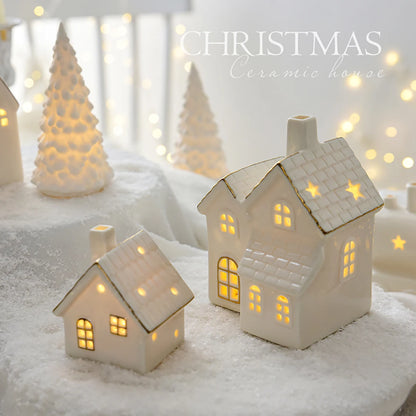 A set of ceramic Christmas houses with lights, designed to create a mini Christmas village scene, placed on a surface with snow and decorative lights.
