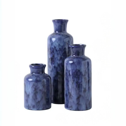 Set of three blue marble-textured vases on a white background