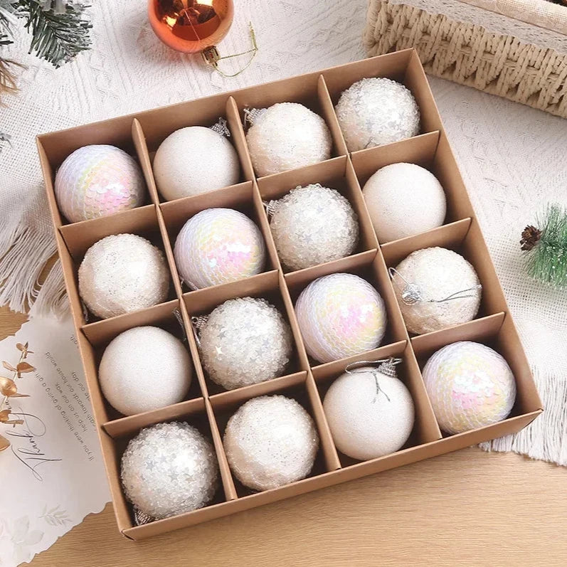 A set of 16 white sparkly, textured Christmas baubles, presented in open cardboard box.