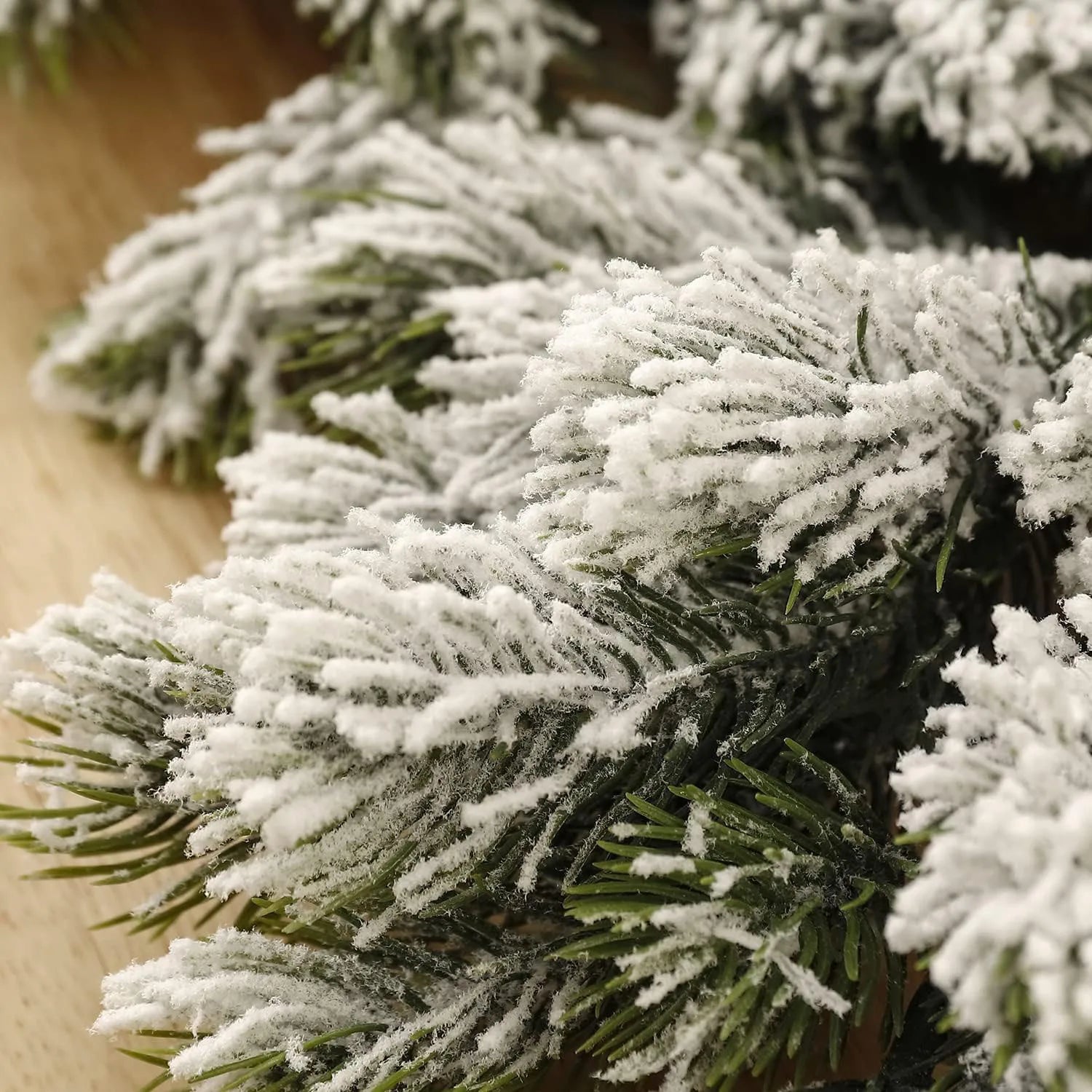 A close-up image of a snowy Christmas garland with frosted pine needles.