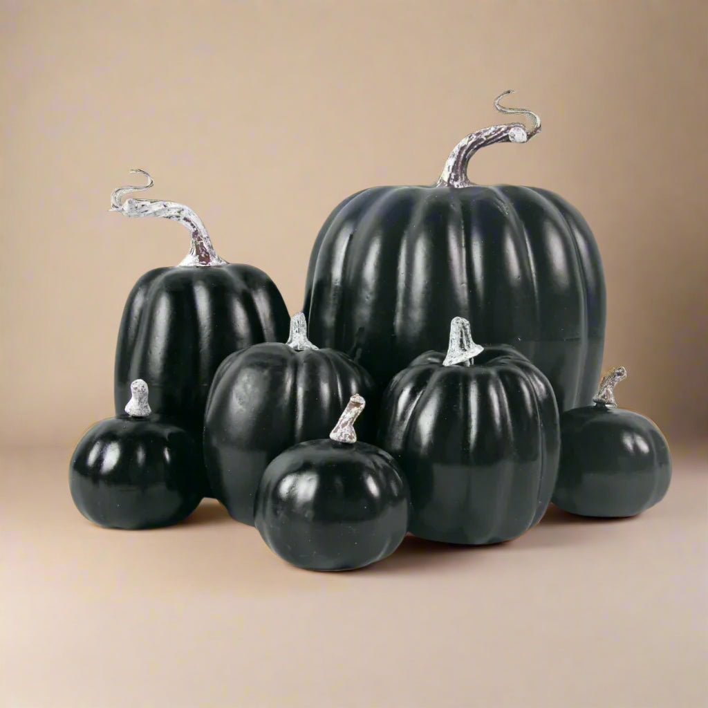 Set of black faux pumpkins on a white background