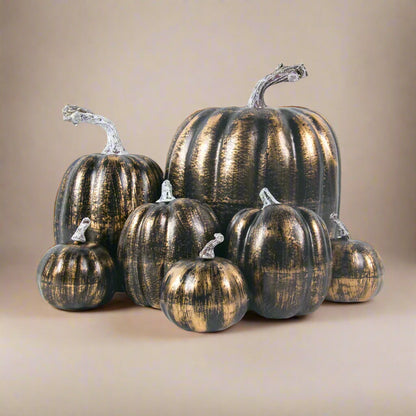 Set of metallic gold and brown faux pumpkins on a white background