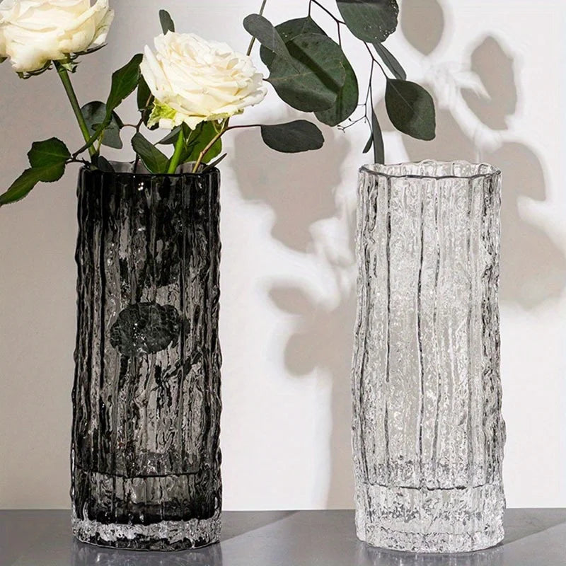 Two decorative vases with textured, ripple effect surfaces, one smokey grey and one clear, on a neutral background.