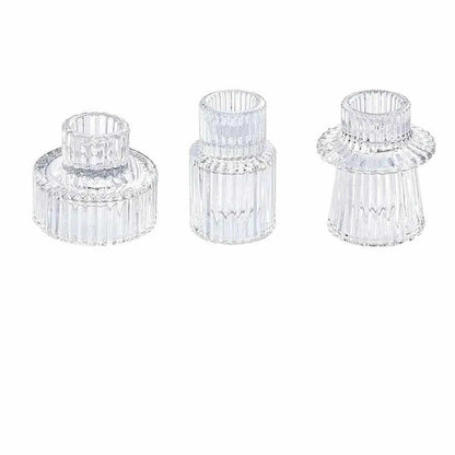 Three clear glass candle holders on a white background