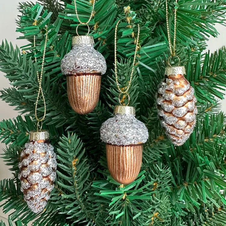 Glass pine cone and acorn ornaments with silver glitter. 4-piece set. Nature-inspired and elegant. Ideal for trees, wreaths, or festive accents. 