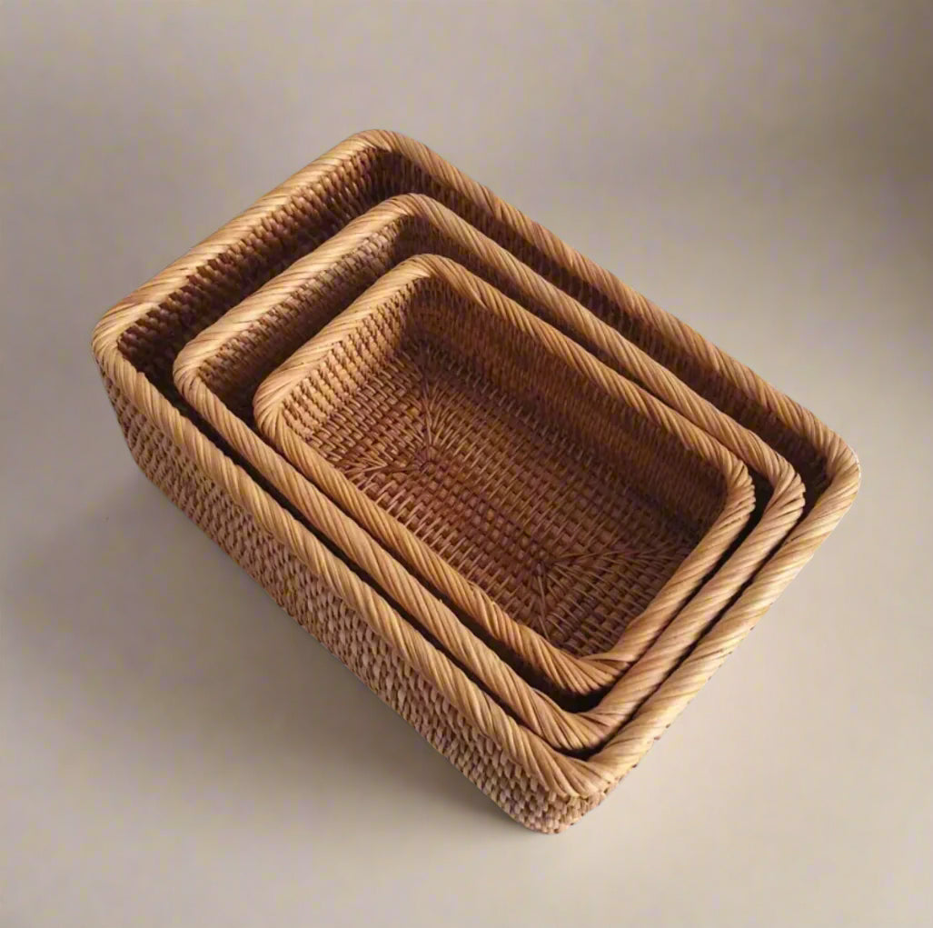 Set of three woven baskets on a white background