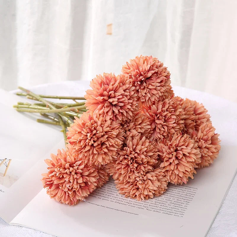 Artificial amber coloured hydrangea arrangement on a white surface