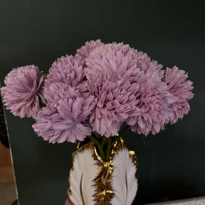 Bouquet of purple flowers in a decorative vase on a dark background