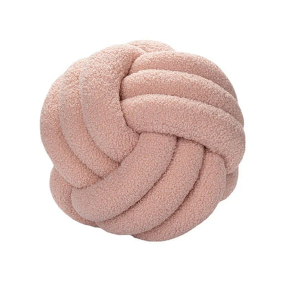 Pink knotted pillow on a white background