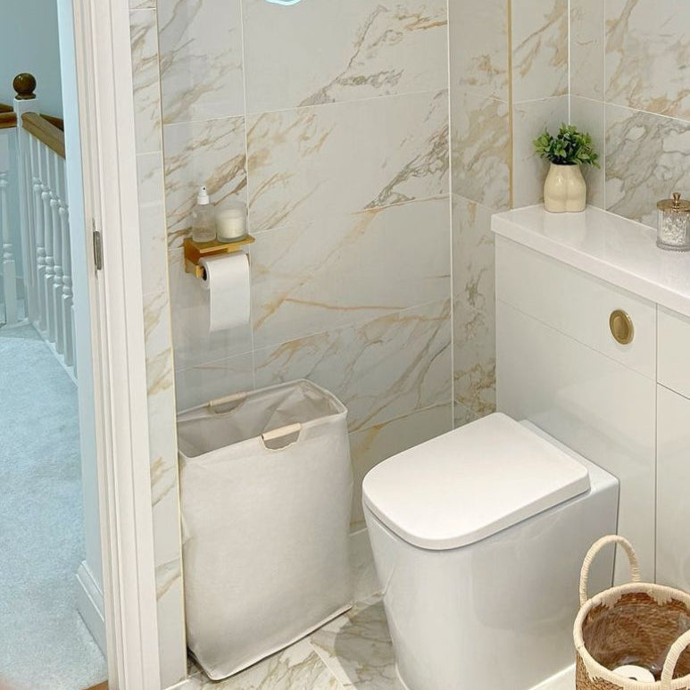 Bathroom setting featuring linen laundry basket with bamboo handle.