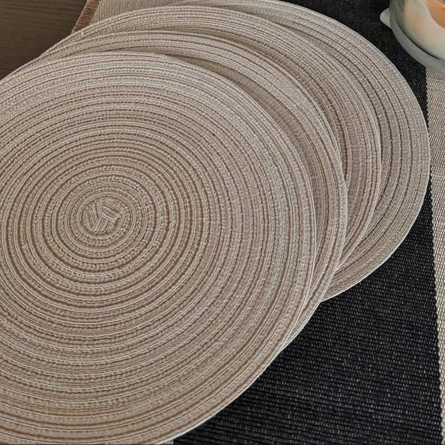 Round linen woven placemats on a dark surface