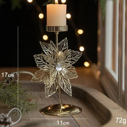 A gold metal candle holder with a festive Christmas flower engraving