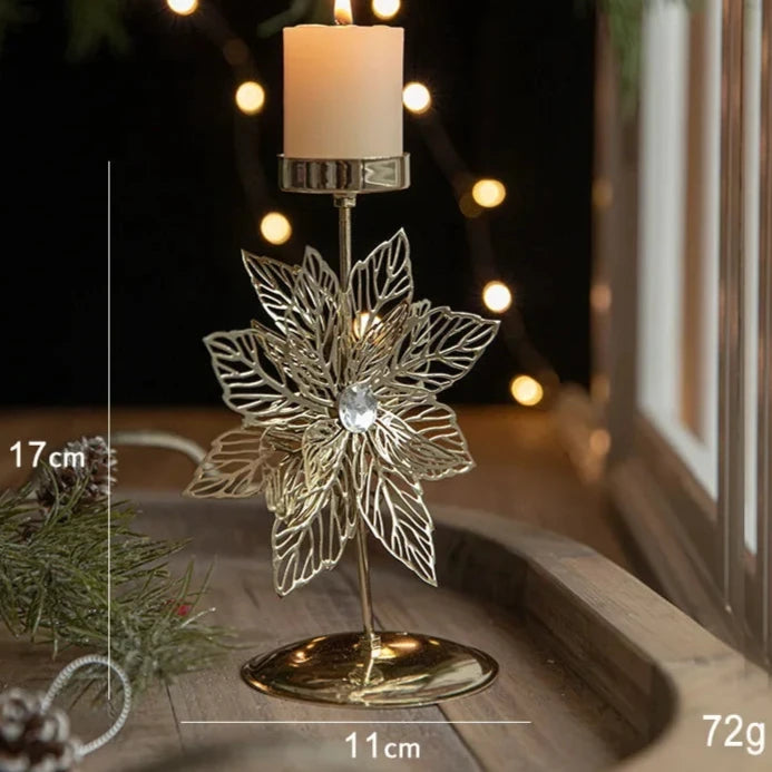 A gold metal candle holder with a festive Christmas flower engraving