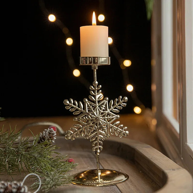 A gold metal candle holder with a festive snowflake engraving