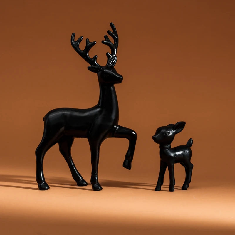 Black deer and fawn figurines on a brown background