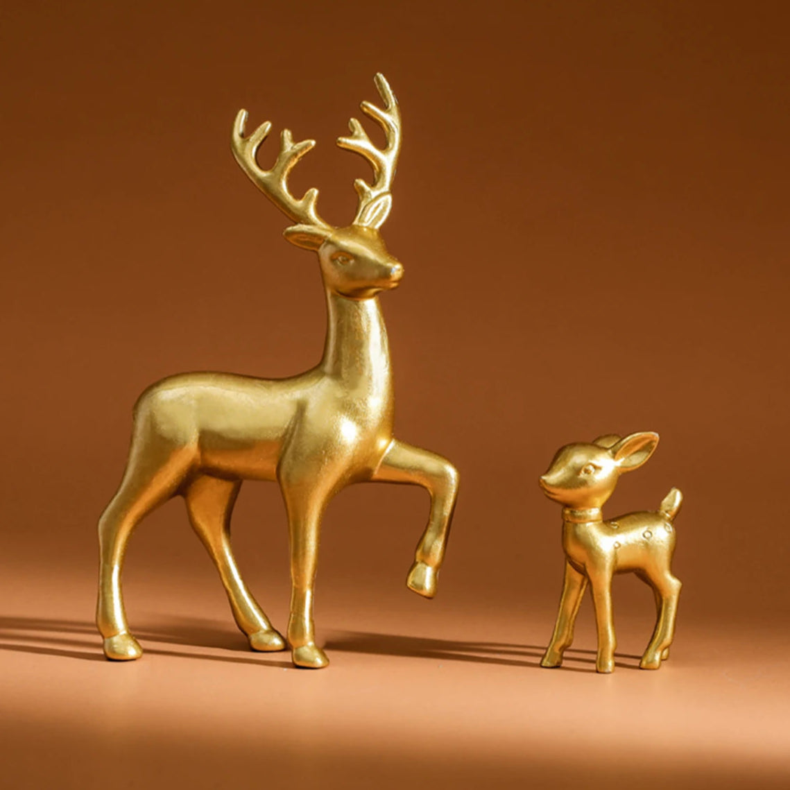 Gold deer figurines on a brown background