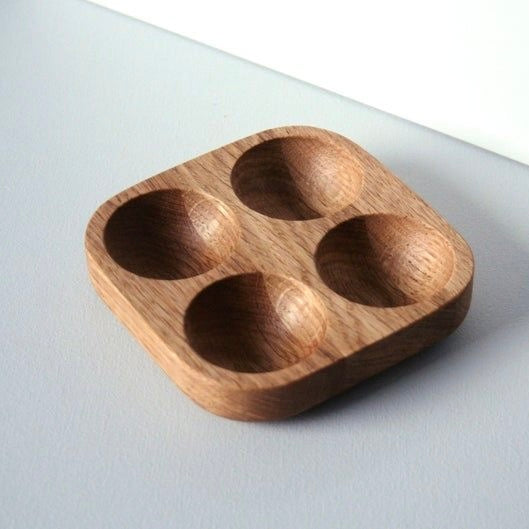 Wooden tray with four compartments on a light grey background