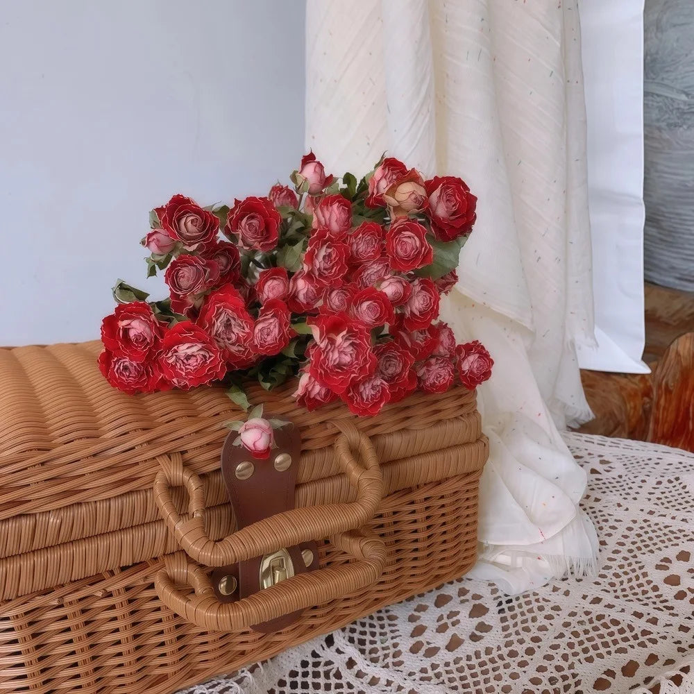 Wicker basket with rosy blend coloured dried roses on a lace tablecloth