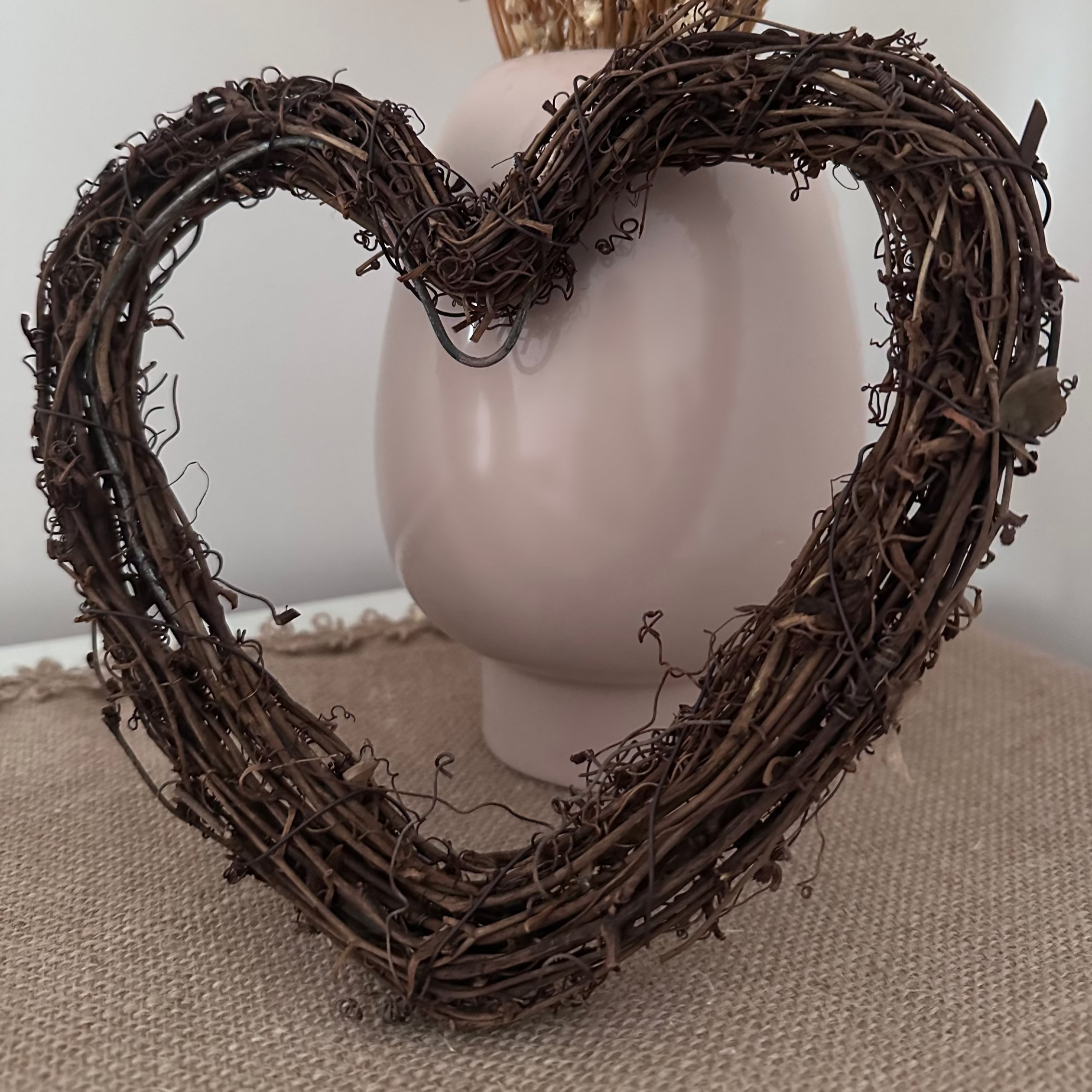 Heart-shaped wreath with dried flowers on a neutral background