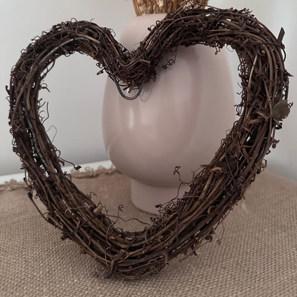 Heart-shaped wreath with dried flowers on a neutral background