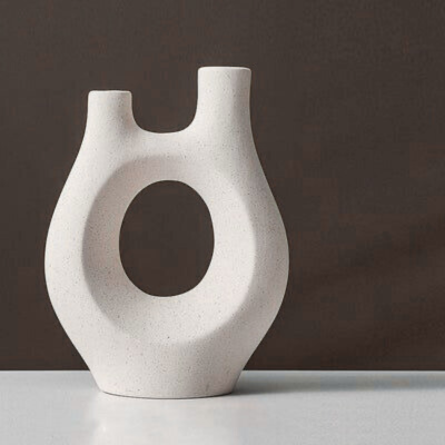White abstract vase on a gray surface with a dark background