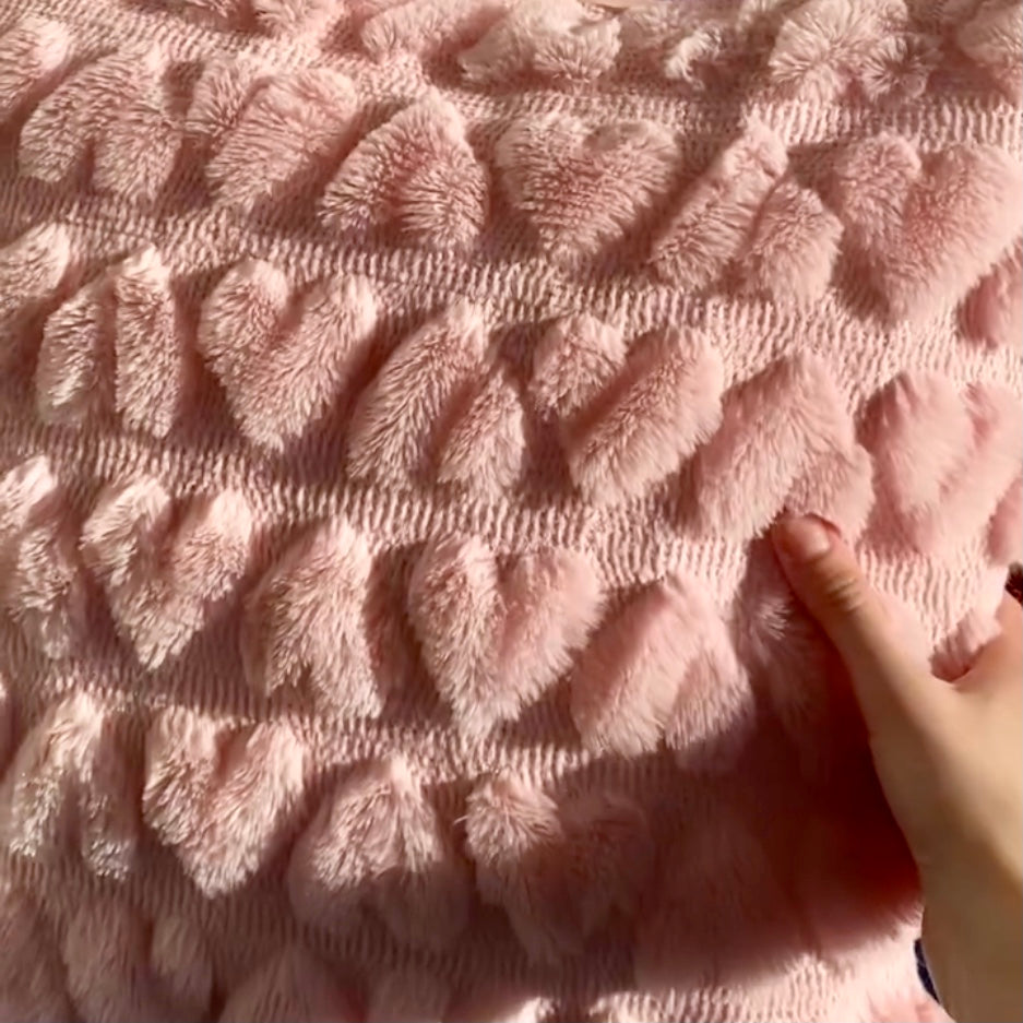 A close up image of the love heart pillow cover showing how fluffy the texture is