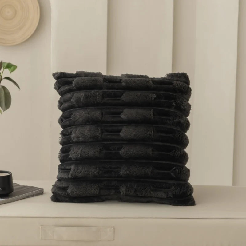 Black textured cushion on a white surface with a neutral background