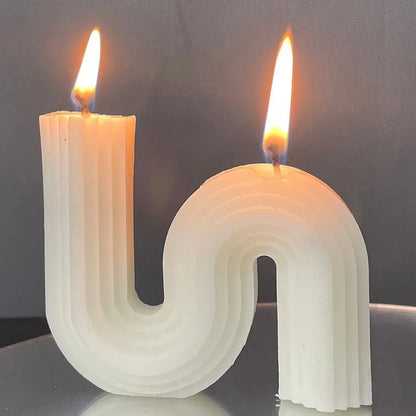 A decorative S-shaped candle made from soy wax in the colour white