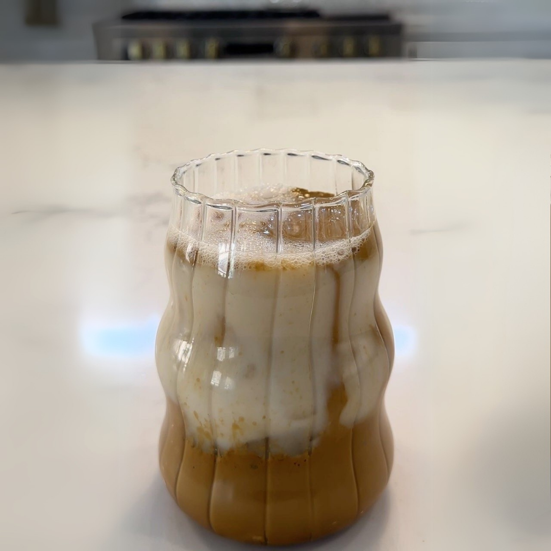 Striped aesthetic, retro glass with layered drink on a white surface